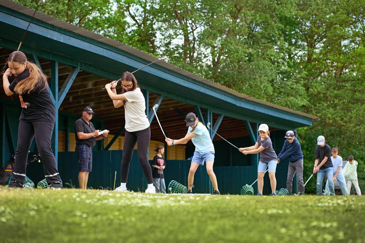 Schüler beim Golfabschlag auf dem Golfplatz